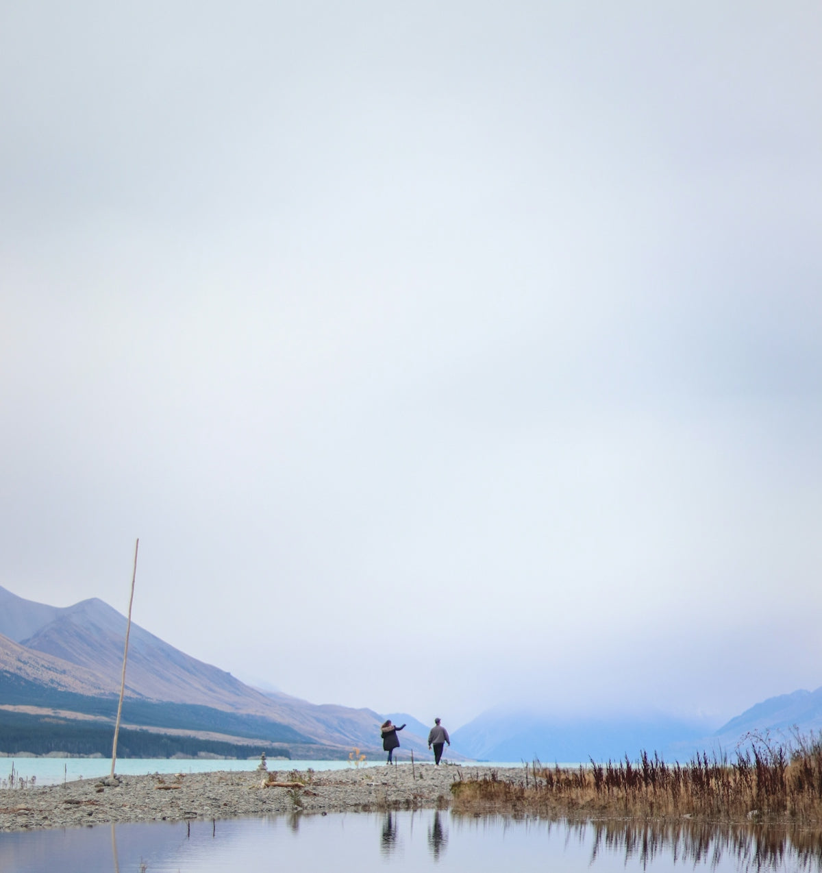 two person standing near body of water