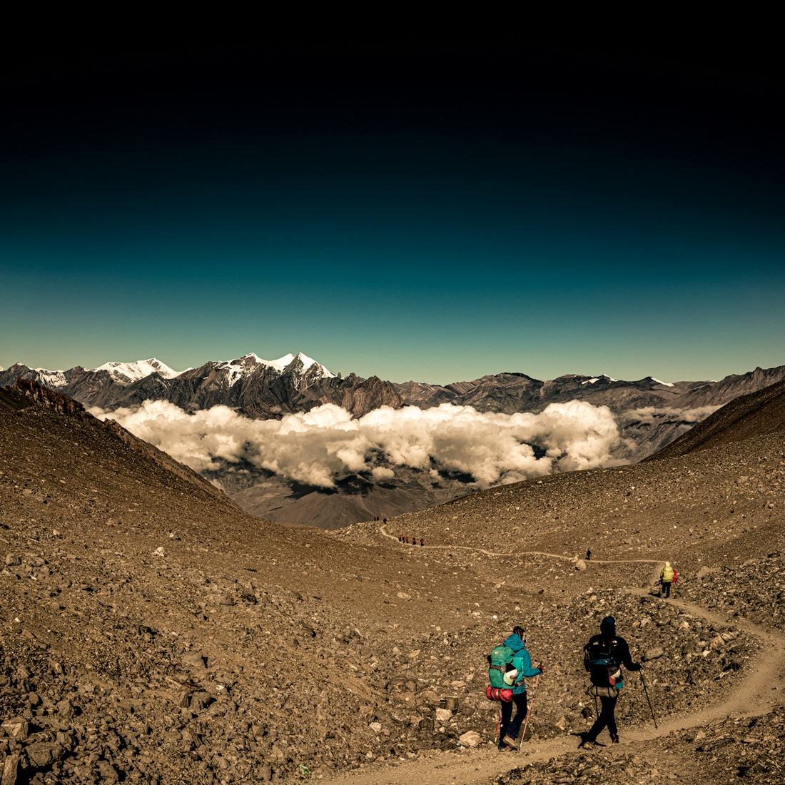two people walking pathway towards mountain