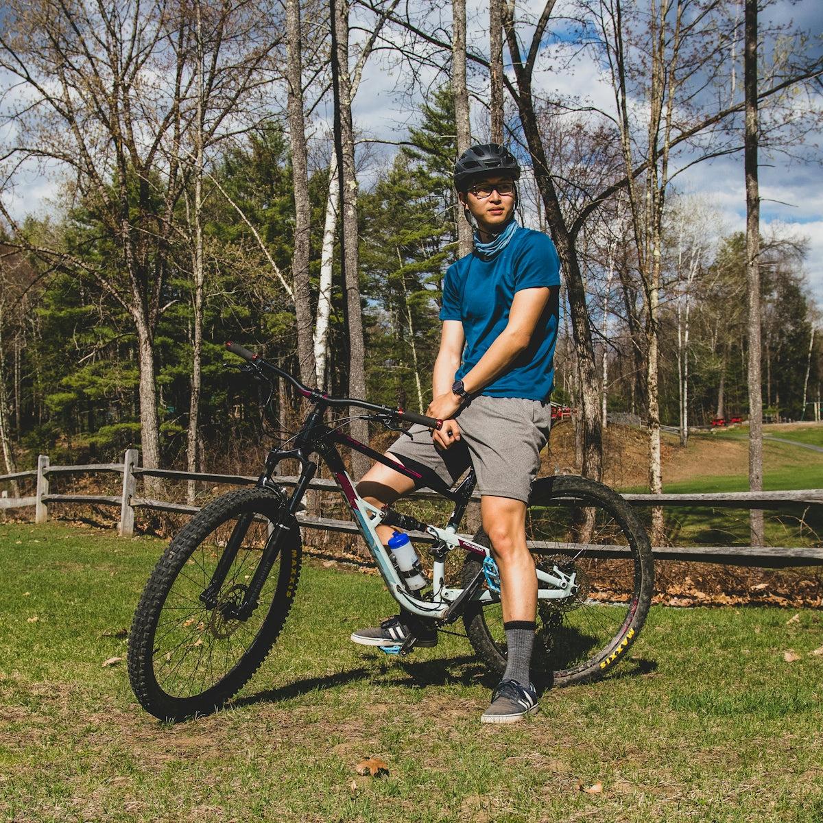 a man standing next to a bike in a park