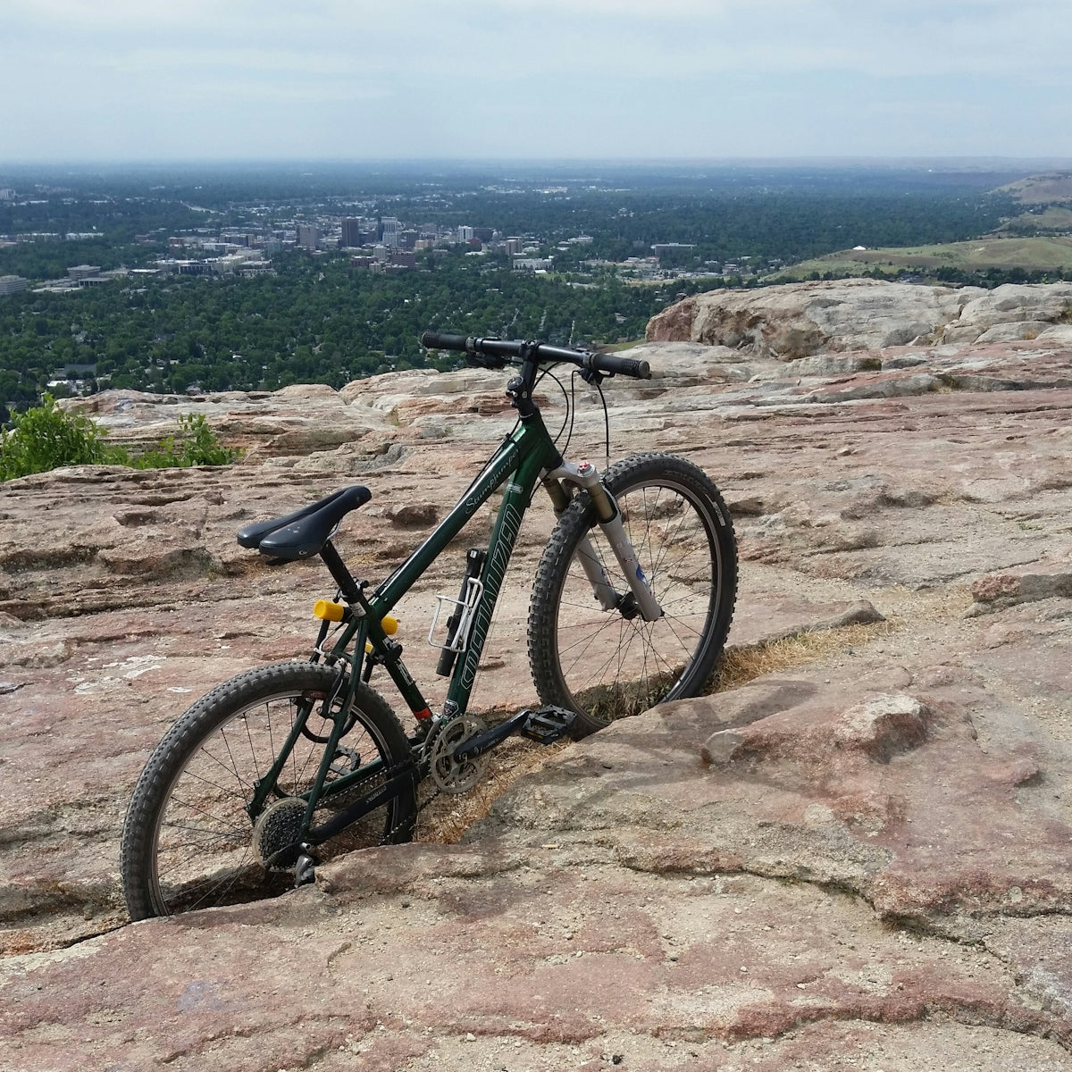 Mountain bike on rocky overlook with city view