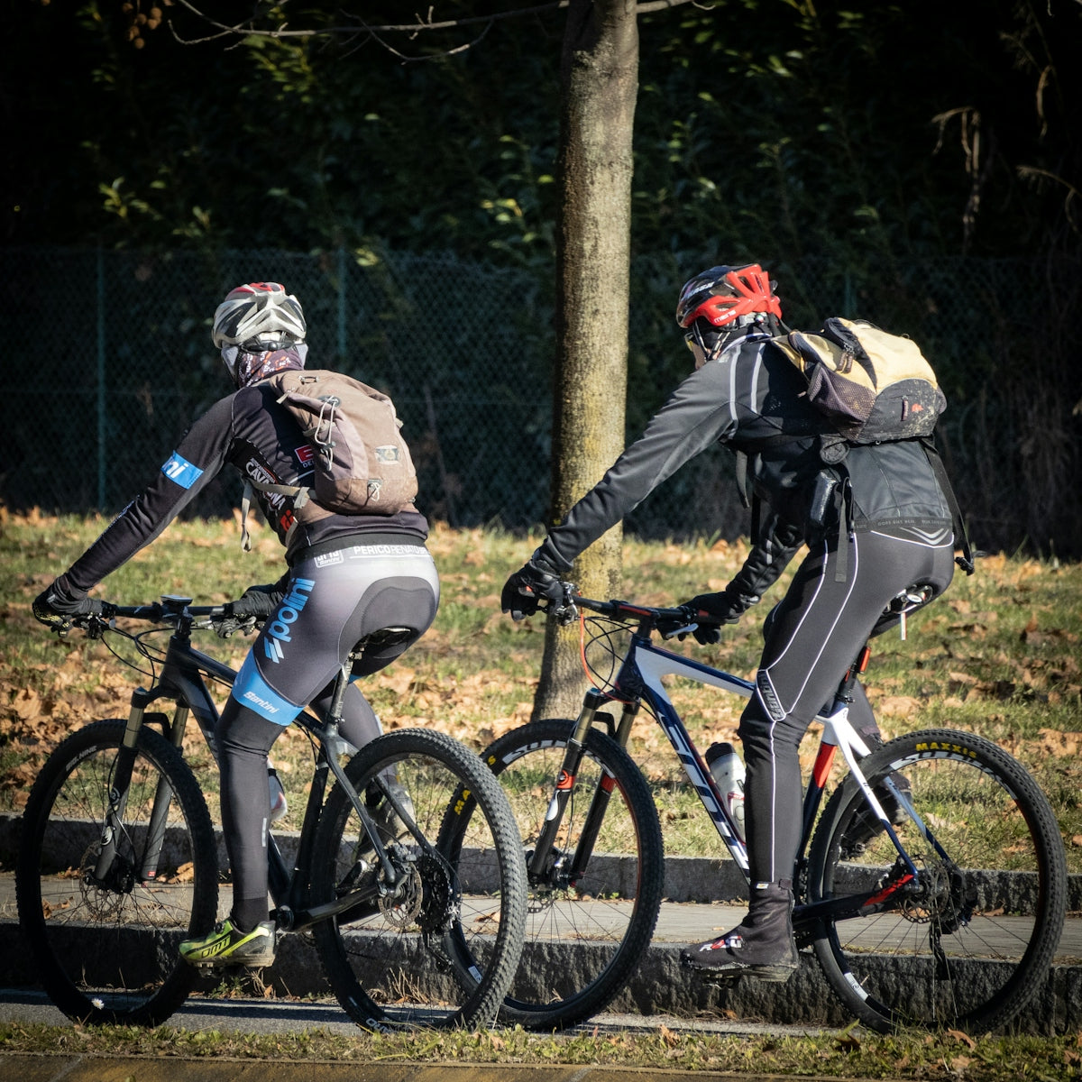 A couple of people riding bikes down a street