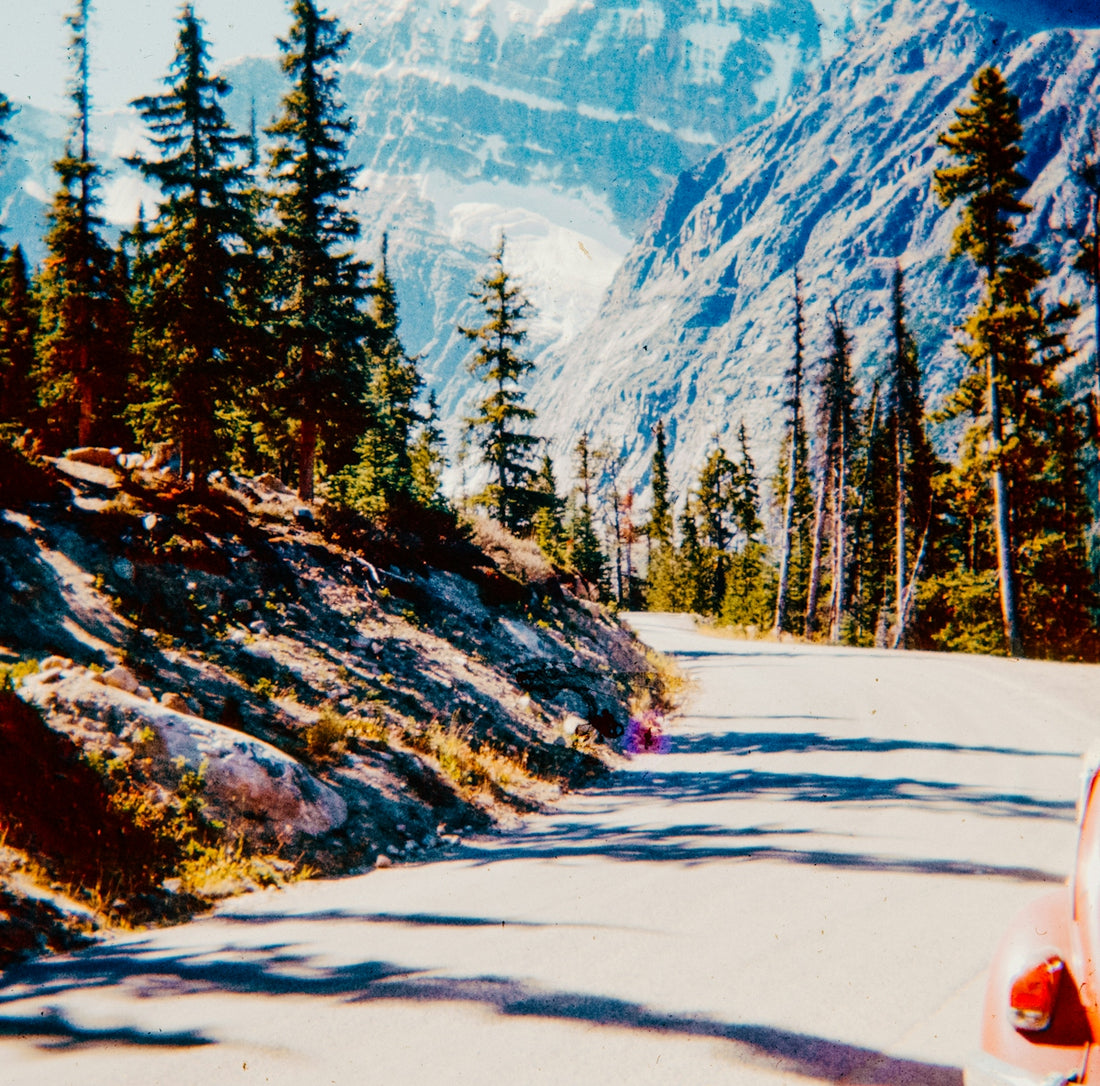 A car driving down a road next to a mountain