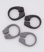Four MTB AirGrips Spare Clamps—two black and two gray ring-shaped plastic clips—are arranged on a white background. Each interchangeable clamp, featuring a small mountain symbol, fits as replacement hardware for AirGrip bar clamps.
