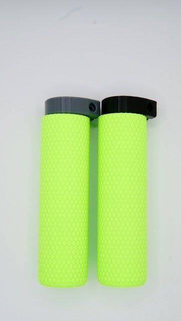 The MTB Air Grips - Green Monstah! set includes two neon yellow mountain bike grips with textured, knurled surfaces. One grip has a gray locking ring and the other a black one, both positioned at the top.