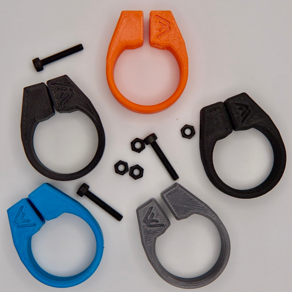 Five MTB AirGrips 3D-printed bar clamps in orange, black, blue, and gray form a circle around three screws and four hex nuts—ideal spare parts—displayed on a white background.